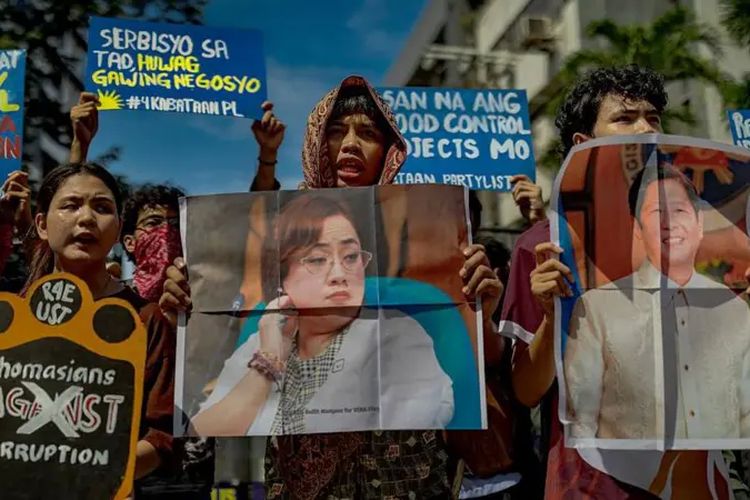 Pengunjuk rasa membawa poster dan foto Presiden Filipina Ferdinand Marcos dan kontraktor Sara Discaya.