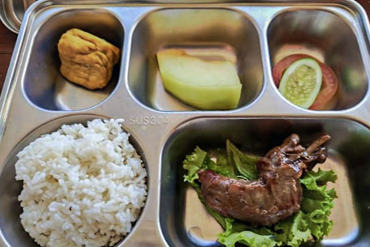 Penampakan 1 porsi menu MBG berisi nasi, ayam kecap, tahu goreng, sepotong melon, dan lalapan berupa selembar daun selada, seiris tomat, serta satu iris timun yang dibagikan kepada 3600 siswa di Kecamatan Cipongkor, Bandung Barat, Senin (21/9/2025).